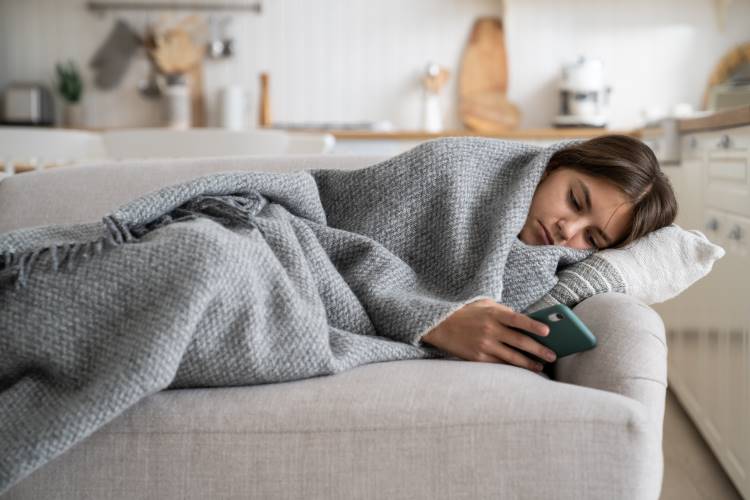 lazy holidays child social media couch blanket cell phone
