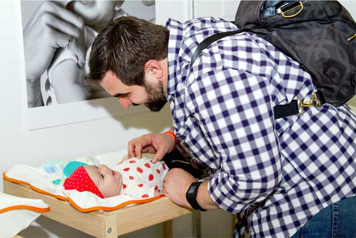 engaged father changes baby diaper