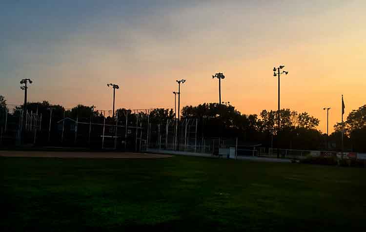empty baseball field at sunset