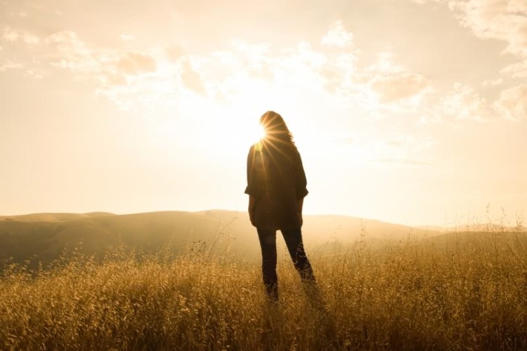 woman in meadow sunset