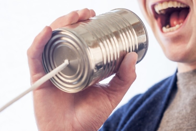 communication man talks into tin can